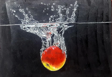 A bright red fruit captured beneath a dramatic water splash